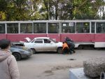 20130930-004 Пассажиры и кондуктор трамвая оттаскивают передок автомашины, чтобы проехал трамвай