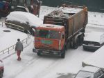 Тракторист руководит выездом мусоровоза от площадки